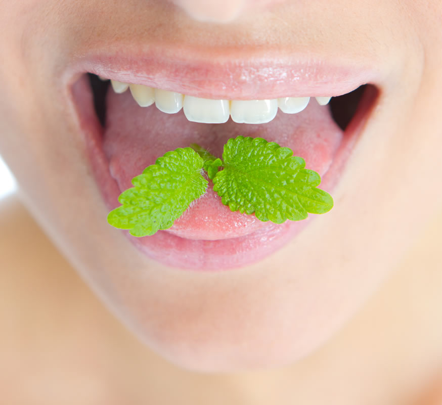 person eating a mint leaf for fresh breath